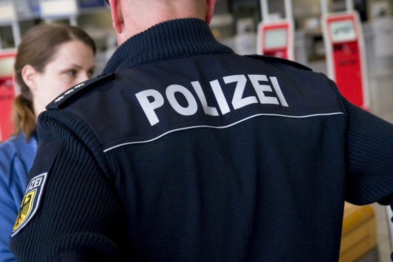 Polizist mit Uniform, Blick auf das Rückenschild "POLIZEI".